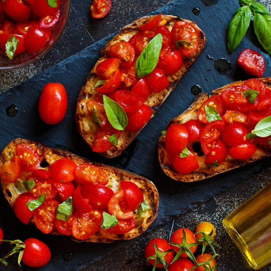 El tomate es uno de los ingredientes principales de la comida italiana. Aquí puede ver tomates sobre delicioso pan italiano crujiente.