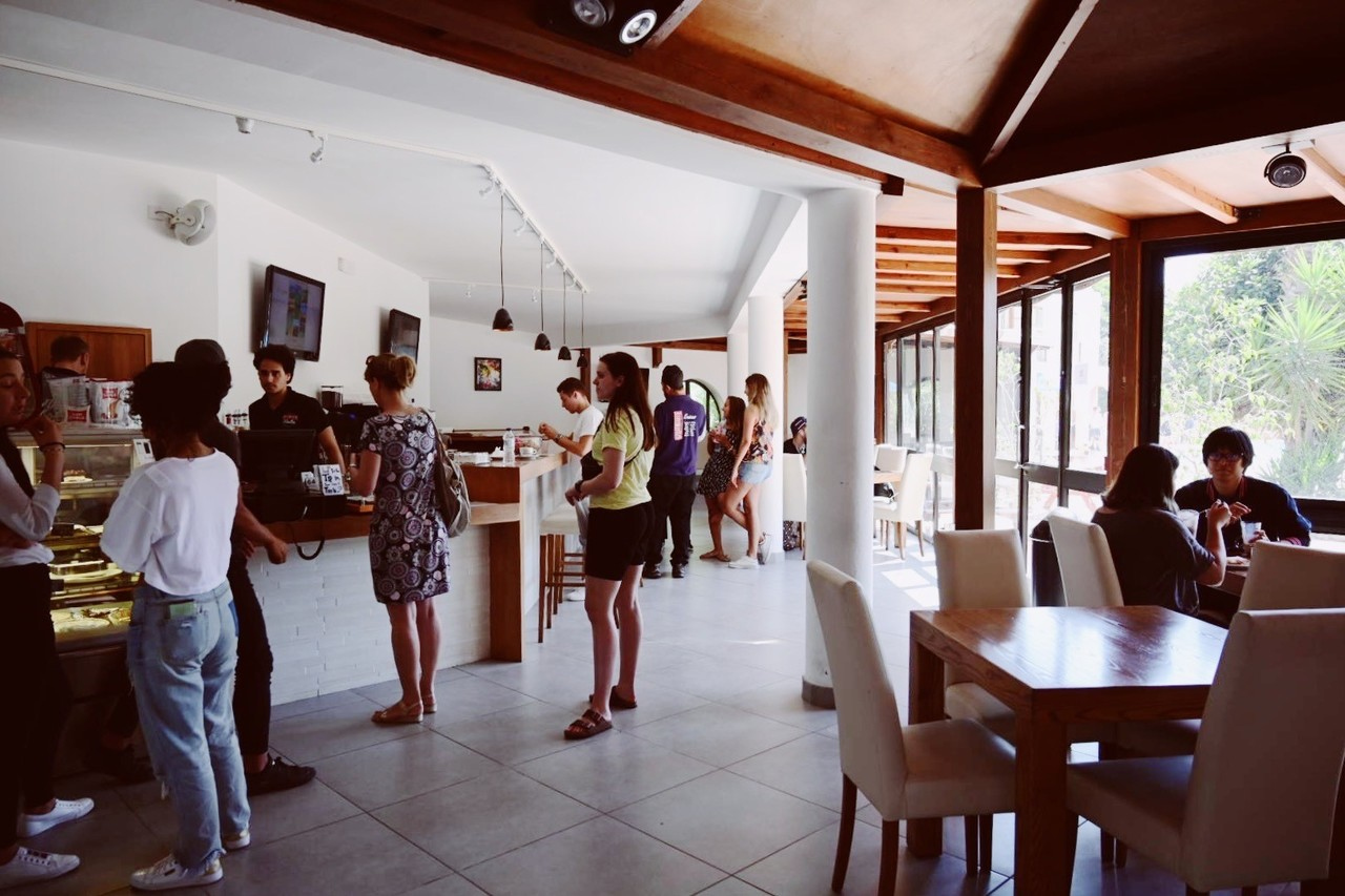 Studenten bestellen eten en kletsen in het lichte en moderne café op de Sprachcaffe Malta campus.