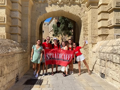 Studenten met Sprachcaffe vlag bij Mdina Gate, Malta.