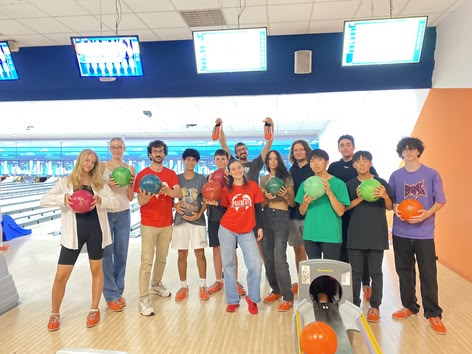 Sprachcaffe leerlingen poseren met bowlingballen tijdens een leuke binnenactiviteit.
