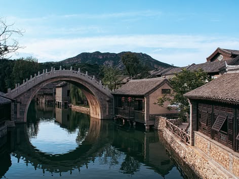 Traditionele stenen boogbrug die weerspiegelt in het kanaal van Wuzhen Water Town, China.