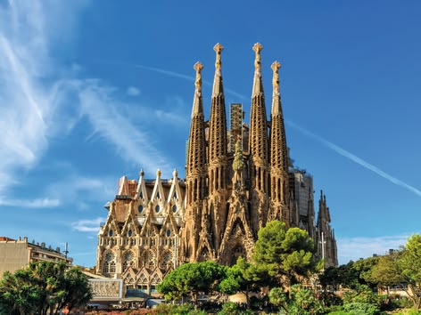 The Sagrada Família basilica in Barcelona under a clear blue sky.