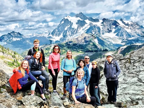 Groep wandelaars poseert in de bergen tijdens een buitenexcursie.